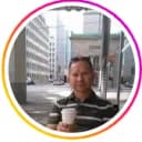 Man holding a coffee with the city in the background